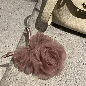 Vue détail chouchou fleur en organza, accessoire de coiffure mauve élégant pour femme.