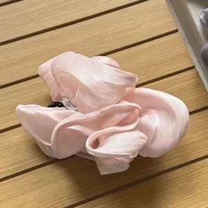 Detailansicht der oversized rosa glänzenden Plissee-Haarklammer, koreanischer Zopfgummi-Stil.