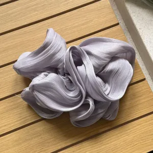 Detailaufnahme des übergroßen metallic plissierten Haargummis mit weicher Textur in hellem Lilaton.