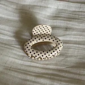 Beige polka dot hair claw clip, cute oval acetate hair accessory for women and daily styling.