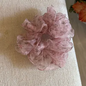Nahaufnahme der rosa floralen, transparenten Organza Haargummi zeigt die schöne Textur.