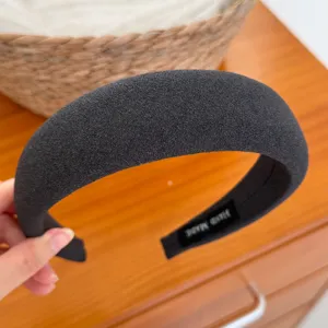 Vista dettagliata della fascia per capelli imbottita grigia scura, tessuto morbido, accessorio.