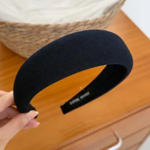 Vista dettagliata della fascia per capelli imbottita blu scuro, accessorio capelli donna.