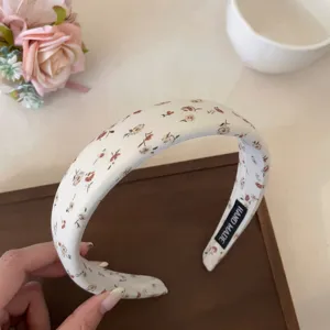 Primer plano detallado de diadema floral dulce, accesorio de tela blanca, diseño delicado.
