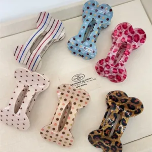 Detailed view of cute bone shaped hair claws featuring polka dots, stripes and leopard prints.