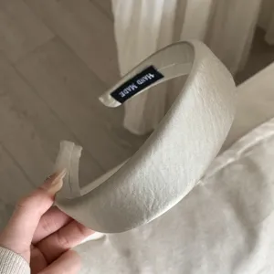 Detailansicht des Satin Haarreifs, glänzende Oberfläche, weiches Design für elegante Frisuren.