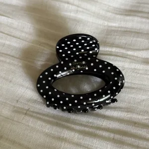 Black and white polka dot oval hair claw clip detail, stylish acetate small hair accessory.