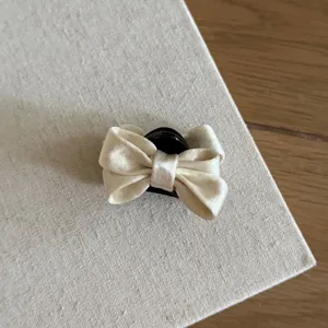 Exquisite satin bow hair claw in elegant beige, perfect for styling chic half-up hairstyles.