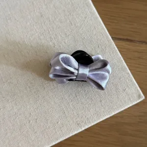 Close-up detail of a light purple satin bow hair claw clip, elegant hair accessory for styling.