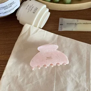 Chic pink acetate hair claw clip detail, elegant French style medium hair accessory for women.