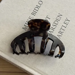 Detailed view of vintage tortoiseshell hair claw clip, large acetate shark clip for thick hair.