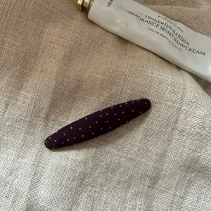 Detaillierte Nahaufnahme einer schicken dunklen langen Haarklammer mit blauem Polka-Dot.