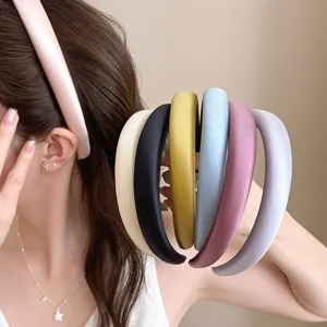 Close-up detail shot of colorful satin sponge headbands showcasing various solid colors.