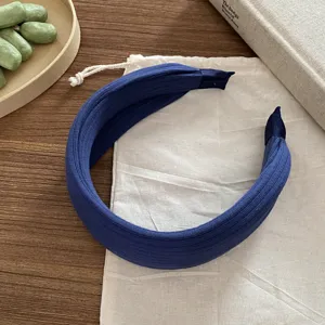 Vue détaillée d'un élégant serre-tête large en tricot côtelé bleu marine chic et tendance.
