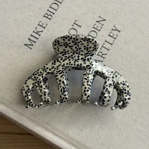 Retro acetate hair claw clip with black and white spotted pattern for thick hair styling.