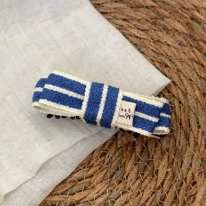 Blue and white striped fabric hair clip detail shot showing the woven texture and bow label.