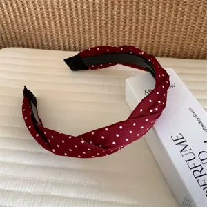Detailansicht eines koreanischen vintage roten Pünktchen gedrehten Haarreifs für Damen.