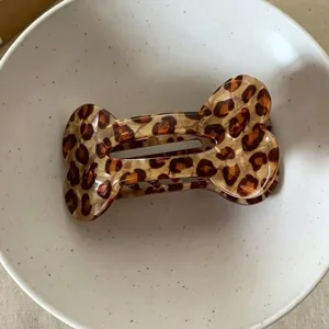 Bone-shaped leopard hair claw detail, stylish acrylic hair accessory for half updo hairstyles.