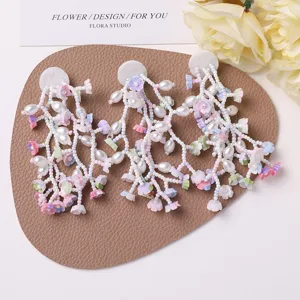 Close-up of handmade beaded flower pearl tassel DIY craft applique for fashion accessories.