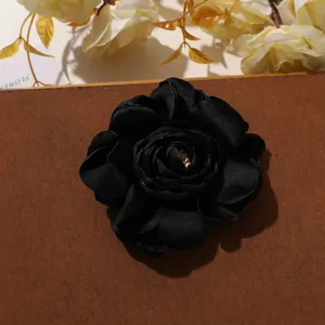 Nahaufnahme der eleganten schwarzen Satin Kamelie Stoffblume, ideal für DIY Bastelarbeiten.