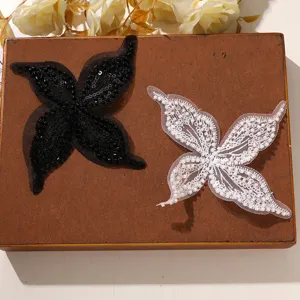 Dettaglio patch farfalla con perline in rete bianco nero, decorazione vestiti e capelli.