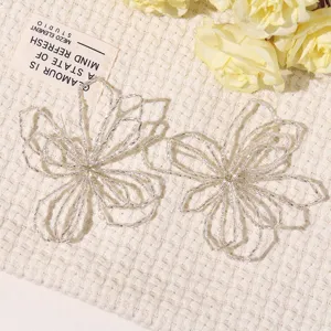 Detalle de accesorio artesanal de flor hueca con cuentas plateadas para joyería hecha a mano.