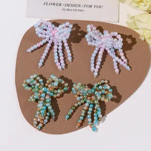 Detailed closeup of handmade beaded bow tassels showing intricate pearl and crystal beadwork.
