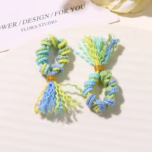 Dettaglio di mini nappa in cotone intrecciato a mano, ciondolo DIY colorato per hobbistica.