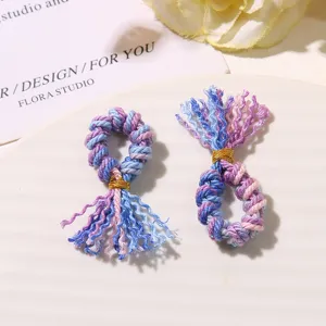 Primo piano di mini nappe accessori fai-da-te, fili di cotone intrecciati colorati con filo d'oro.