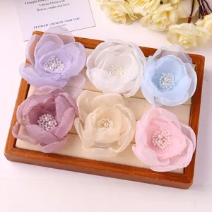 Sweet mesh flower hair clip detail showcasing pastel floral design with faux pearls, perfect for spring.