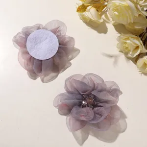 Organza flower accessory close-up, gradient peony petals, beaded center detail view.