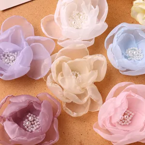 Colorful mesh fabric flower hair accessories with pearl centers, delicate crafting details.