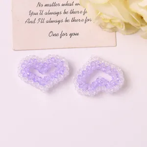 Close-up detail of purple and clear beaded heart DIY accessories, perfect for hair ties or earrings.