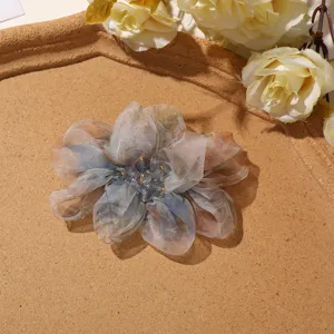 Detailed view of gradient organza flower hair claw clip with crystal bead center.