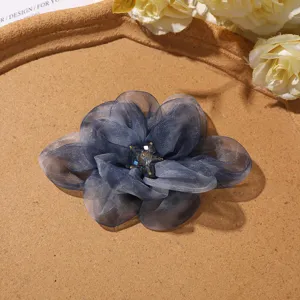 Close-up detail of dark blue gradient organza flower hair claw accessory with crystal center.