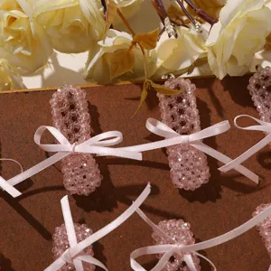 Close-up of pink beaded crystal shoe charms with cute satin ribbon bows for DIY accessories.