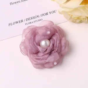 Detailed view of the pink chiffon camellia flower accessory with faux pearls for DIY hair clips.