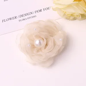 Detailed view of elegant mesh camellia flower with faux pearl for DIY hair clips or brooches.