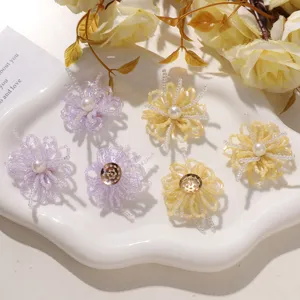 Detalle en primer plano de accesorios florales de cuentas hechos a mano con perlas delicadas.