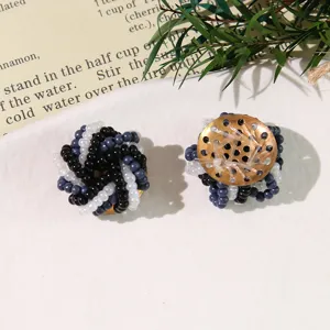 Primo piano di accessori di fiori di perline fatti a mano, dettaglio di gioielli DIY coordinati.