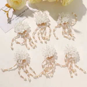 Detail shot of handmade beaded flower charms with crystal tassels, perfect for DIY jewelry.
