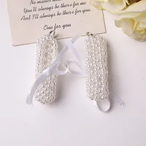 Detailed view of white pearl beaded DIY charm accessory with ribbon and metal ring.