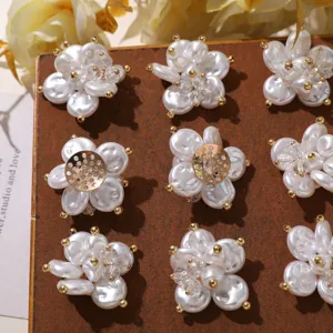 Detailed close-up of pearl crystal camellia DIY shoe charms and brooch accessories.