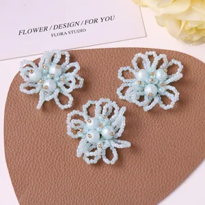 Close-up details of handmade light blue beaded pearl flower craft accessories for decoration.