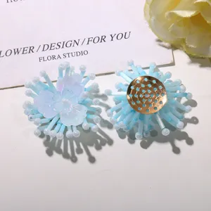 Nahaufnahme von meerblauen Perlenblumen DIY Zubehör, zarte Kristallblüten und goldener Boden.