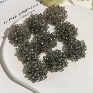 Close-up of shimmering grey crystal beaded flower clusters for DIY craft and apparel accessories.