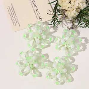 Close-up detail of green and white beaded flower handmade DIY accessories for jewelry and crafts.