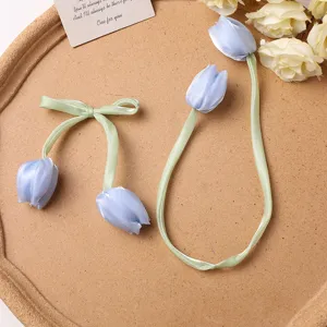 Blue fabric tulip flower buds and green ribbon bow DIY hair accessories crafting components.