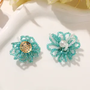 Primer plano de flores de cuentas azules y blancas hechas a mano, ideal para pendientes y accesorios.