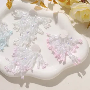 Handcrafted beaded floral tassel detail shot, delicate pink and white diy patch accessory.